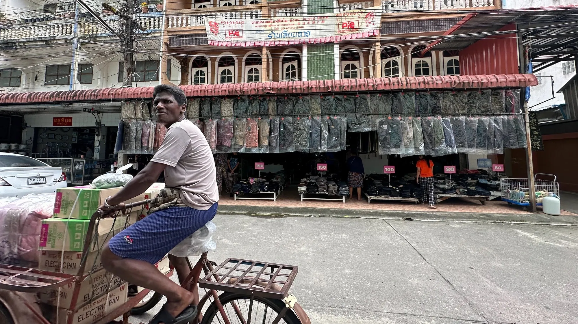 Street in Mae Sot. In the background is a military supply shop, above which hangs a Lunar New Year banner from a local Chinese temple.